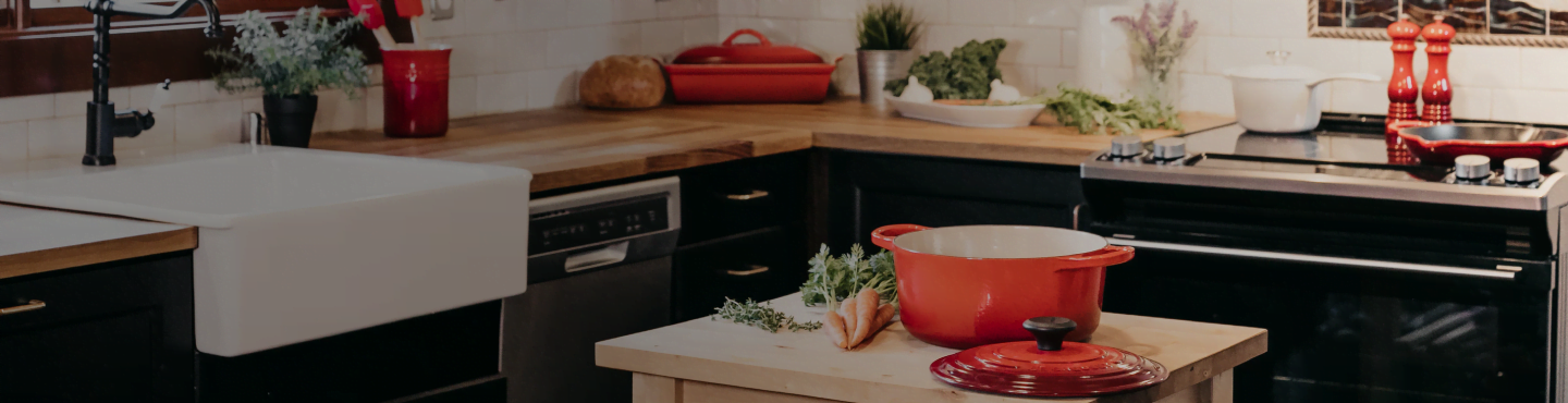 cozinha nova para um casal com panela laranja, forno e utensílios
