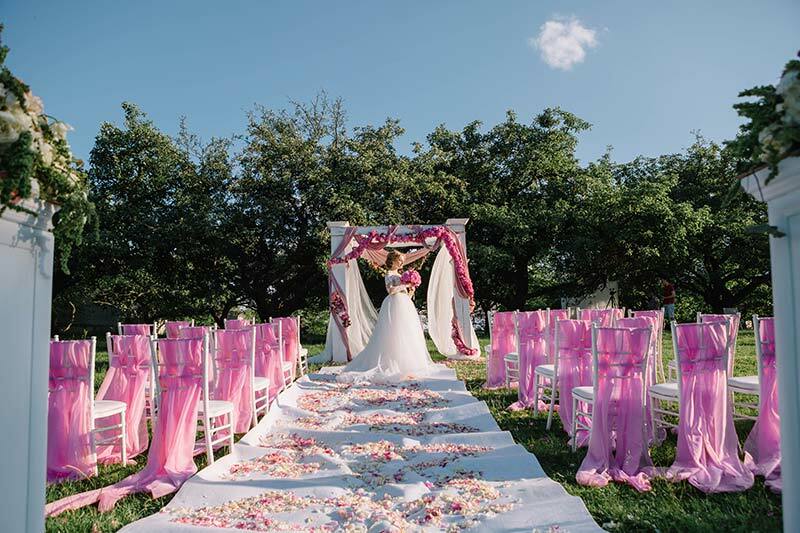 noiva no altar ao ar livre no campo com decoração rosa
